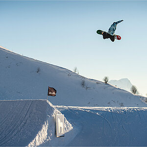 Snowboarder in Luft über Schanze